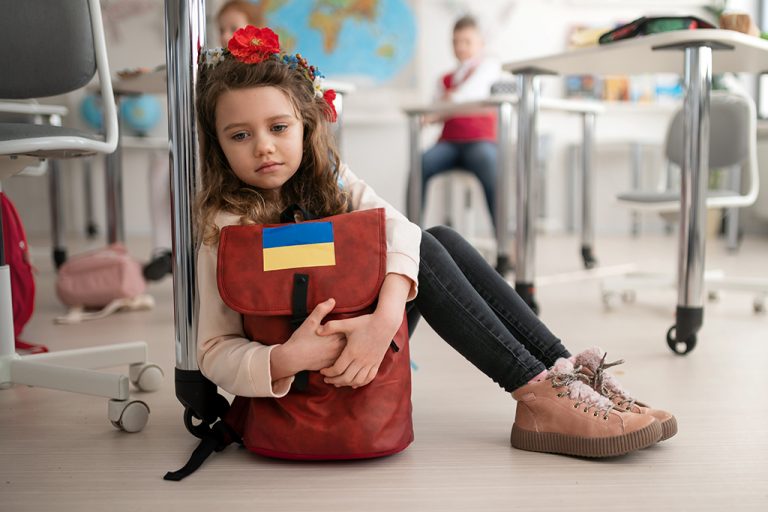 dziewczynka z plecakiem z flagą Ukrainy
